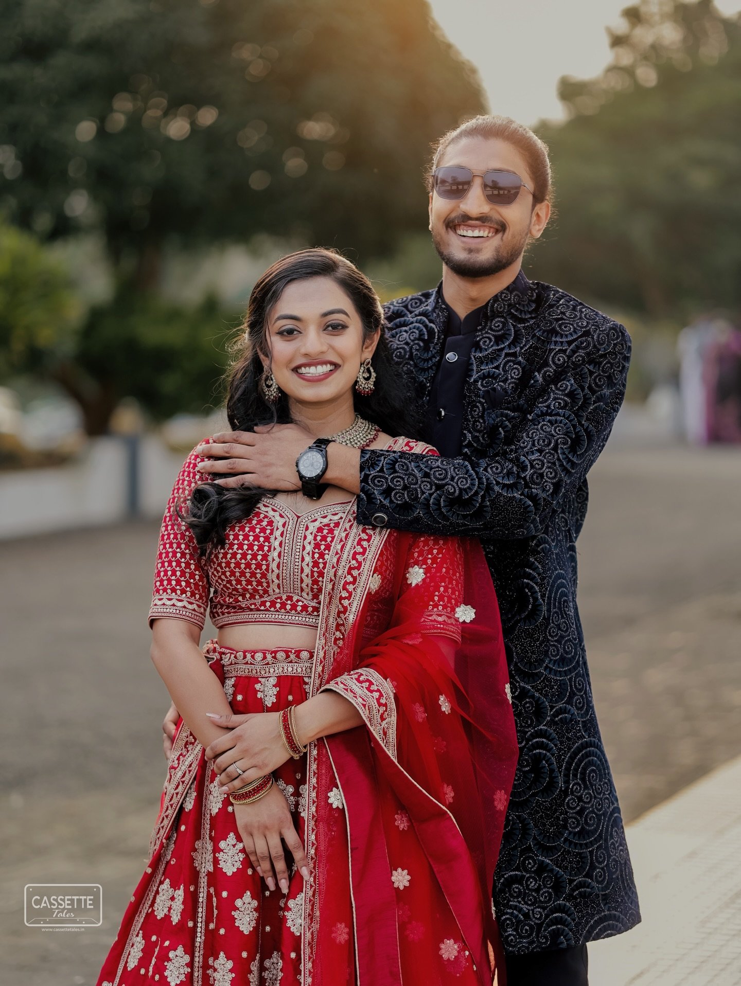 A couple smiling together in red and navy celebration attire