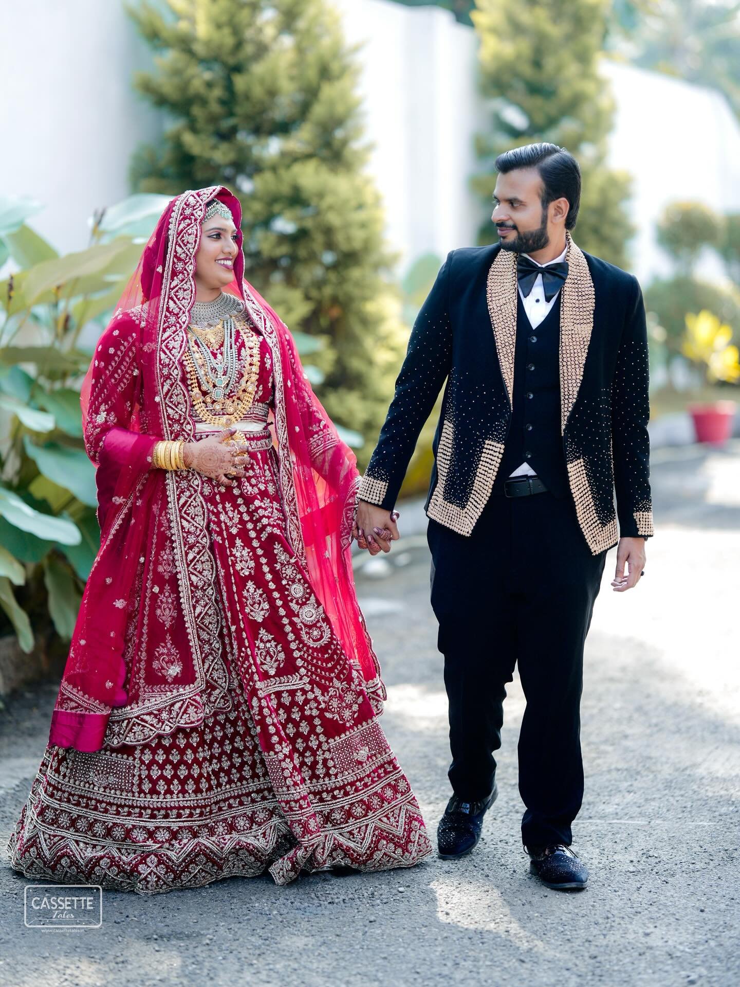 A bride and groom walking hand in hand in their wedding attire